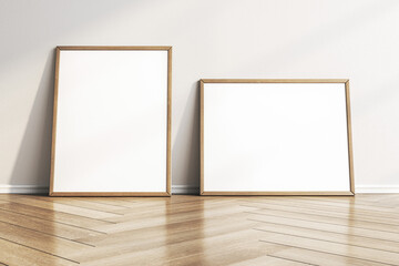 Empty white photo frames leaning on concrete wall in interior with wooden flooring. Mock up, 3D Rendering.