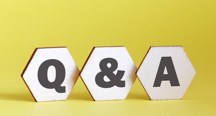 Q and A - an abbreviation of wooden blocks with letters on a yellow background.