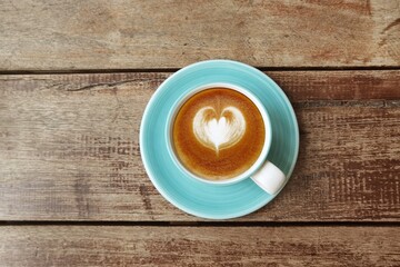 a cup of latte art coffee on wooden background                       