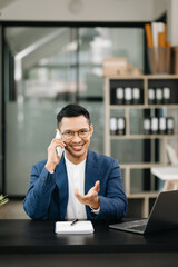 Young business man working at office with laptop, tablet and taking notes on the paper..