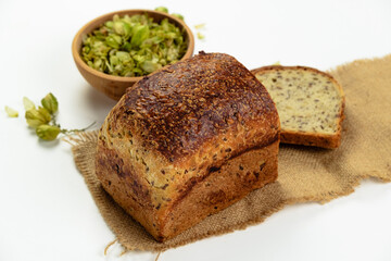 Organic bread of whole grain flour and hop sourdough. Dry hop flowers in wooden bowl and homemade bread. Craft bakery concept