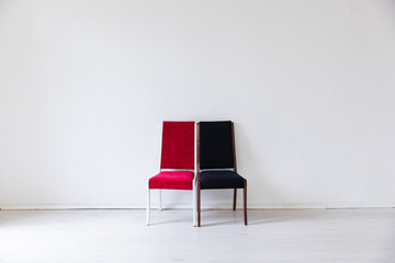 two colorful chairs in the interior of a white empty room