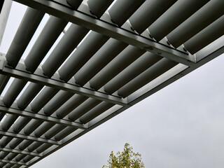 metal construction of the bus stop, gazebo pergola shelter. the roof and walls are braided with a...