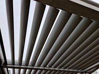 metal construction of the bus stop, gazebo pergola shelter. the roof and walls are braided with a...