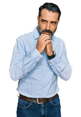 Fototapeta premium Middle aged man with beard wearing business shirt laughing nervous and excited with hands on chin looking to the side