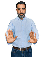 Middle aged man with beard wearing business shirt moving away hands palms showing refusal and...