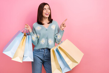 Photo of pretty shiny lady wear turquoise clothes holding shoppers looking pointing empty space...