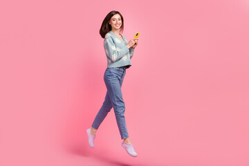 Full length body photo of jump walking blogging lady brown hair wear cardigan texting boyfriend soldier isolated on pink color background - Powered by Adobe