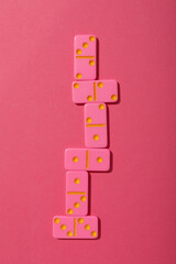 Pink dominoes on pink background, top view