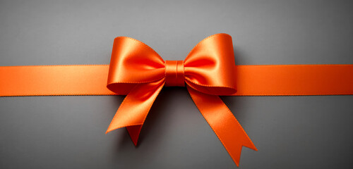 Orange gift ribbon with bow isolated on gray background. Decorative Orange bow with horizontal ribbon. bow for page decor isolated on grey. - obrazy, fototapety, plakaty