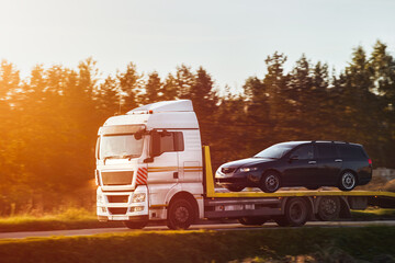 Reliable Towing and Recovery Services: 24-7 Assistance for Vehicle Breakdowns and Accidents. Emergency roadside assistance on the highway. side view of the flatbed tow truck