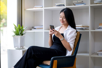 Young asian woman using smart while relaxing at resting corner.