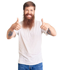 Handsome young red head man with long beard wearing casual white tshirt approving doing positive gesture with hand, thumbs up smiling and happy for success. winner gesture.