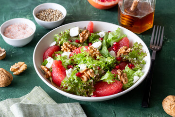 Salad with grapefruit, white cheese, pomegranate and nuts. Healthy eating. Vegetarian food. Diet.