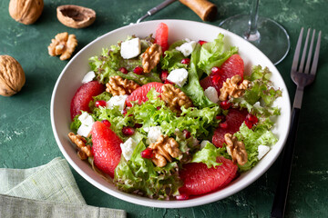 Salad with grapefruit, white cheese, pomegranate and nuts. Healthy eating. Vegetarian food. Diet.