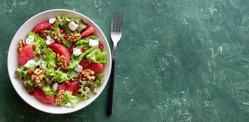 Salad with grapefruit, white cheese, pomegranate and nuts. Healthy eating. Vegetarian food. Diet.