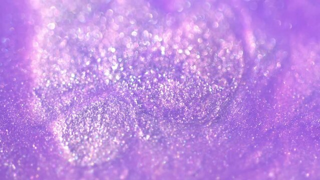 Pastel lilac color liquid pearls paint. Ink flow macro. Glitter fluid motion. Beautiful glitter abstract background