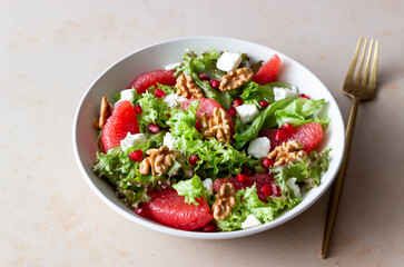 Salad with grapefruit, white cheese, pomegranate and nuts. Healthy eating. Vegetarian food. Diet.