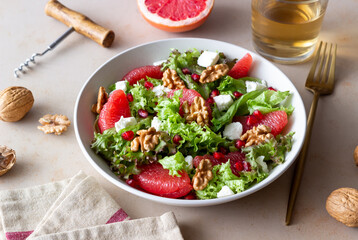 Salad with grapefruit, white cheese, pomegranate and nuts. Healthy eating. Vegetarian food. Diet.