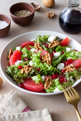 Salad with grapefruit, white cheese, pomegranate and nuts. Healthy eating. Vegetarian food. Diet.