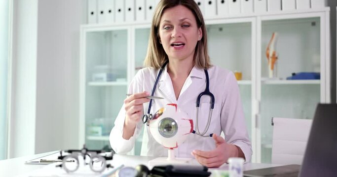 The woman is a doctor shows an anatomical modal eye, a close-up. Ophthalmologist training, medical education