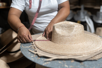 Measuring the brim of a traditional natural fiber hat