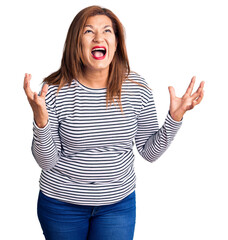Middle age latin woman wearing casual clothes crazy and mad shouting and yelling with aggressive expression and arms raised. frustration concept.