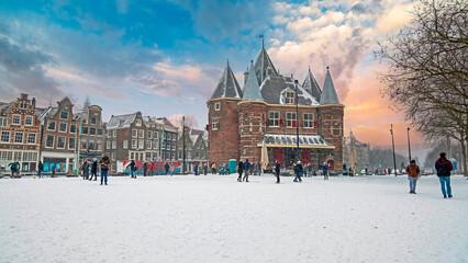 Traditional snowy Waag building at the Nieuwmarkt in Amsterdam in the Netherlands in winter © Nataraj