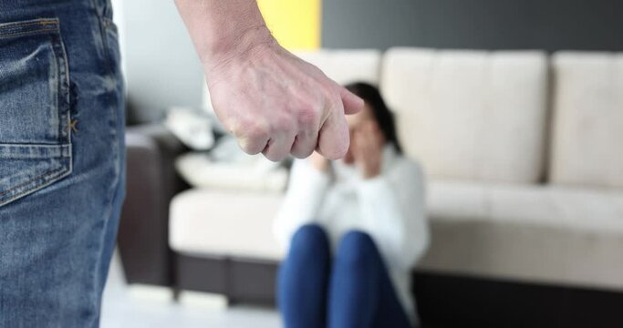 Man folding his fist in front of crying woman closeup 4k movie slow motion. Domestic violence concept