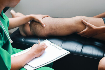 Doctor checking patient foot that suffering from filariasis or lymphatic filariasis and making notes in clipboard - obrazy, fototapety, plakaty