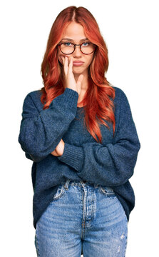 Young redhead woman wearing casual sweater and glasses thinking looking tired and bored with depression problems with crossed arms.