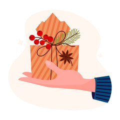 Hand holding christmas box gift cartoon vector illustration. Present in hand. Cartoon gift box with branch fir tree, red berry and anise star..