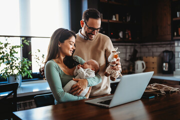 Parents with infant child having video call on laptop at home. Family happiness technology concept. - obrazy, fototapety, plakaty