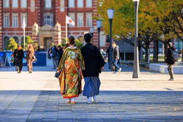 Fototapeta na wymiar 結婚式の前撮りのために街中を歩く新郎新婦