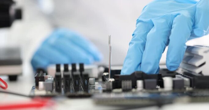 Gloved engineer inserts microcircuit into computer motherboard. Computer hardware concept