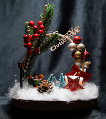 Christmas wreath in the form of a star Blue lights. Symbolic Christmas balls and ornaments. Green, white. On a black background