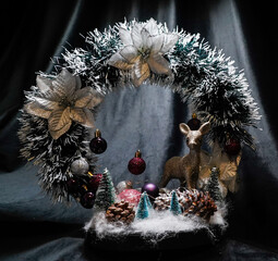 Christmas wreath in the form of a star Blue lights. Symbolic Christmas balls and ornaments. Green, white. On a black background