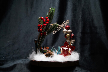 Christmas wreath in the form of a star Blue lights. Symbolic Christmas balls and ornaments. Green, white. On a black background