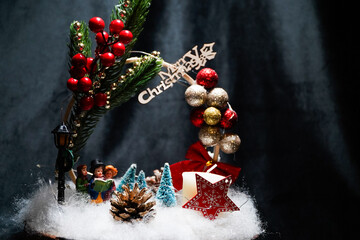 Christmas wreath in the form of a star Blue lights. Symbolic Christmas balls and ornaments. Green, white. On a black background