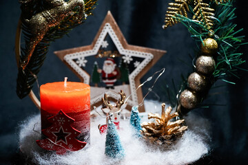 Christmas wreath in the form of a star Blue lights. Symbolic Christmas balls and ornaments. Green, white. On a black background