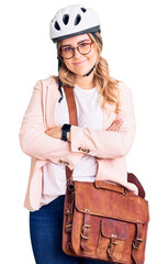 Young caucasian woman wearing bike helmet and leather bag happy face smiling with crossed arms looking at the camera. positive person.