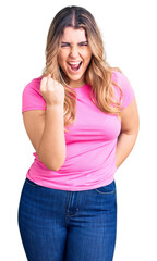 Obraz premium Young caucasian woman wearing sportswear angry and mad raising fist frustrated and furious while shouting with anger. rage and aggressive concept.