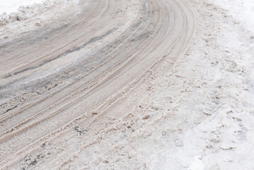 Fototapeta na wymiar Car traces on white snow as a background