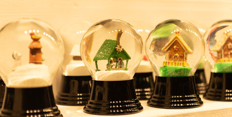 Magical snow globe with decorations and a green small house inside