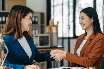 Middle age partner lawyers attorneys shaking hands after discussing a contract agreement done.