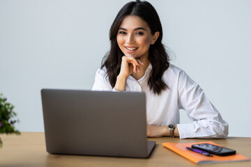 Attractive mature businesswoman working on laptop in her workstation.