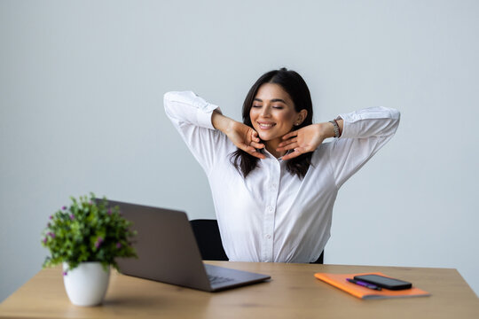 Happy Woman Leaning Back On Chair, Relaxing After Successful Work At Office, Resting With Hands Behind Head