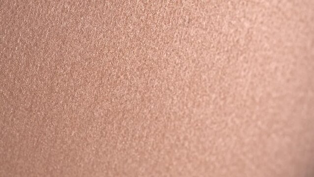 Professional shiny beige eyeshadow, macro. Professional bronzer or highlighter texture, make-up  background, close-up, rotation. Bright brown eye shadows. Cosmetics backdrop. 4K