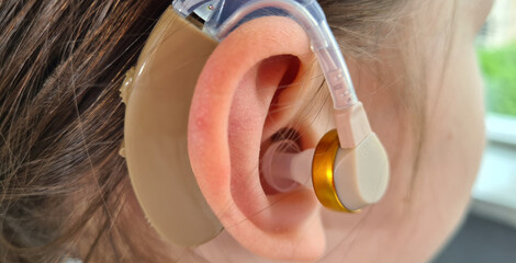 Hearing aid of child and girl suggests hearing aid