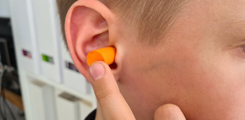 Earplugs are inserted into child ear concept - obrazy, fototapety, plakaty